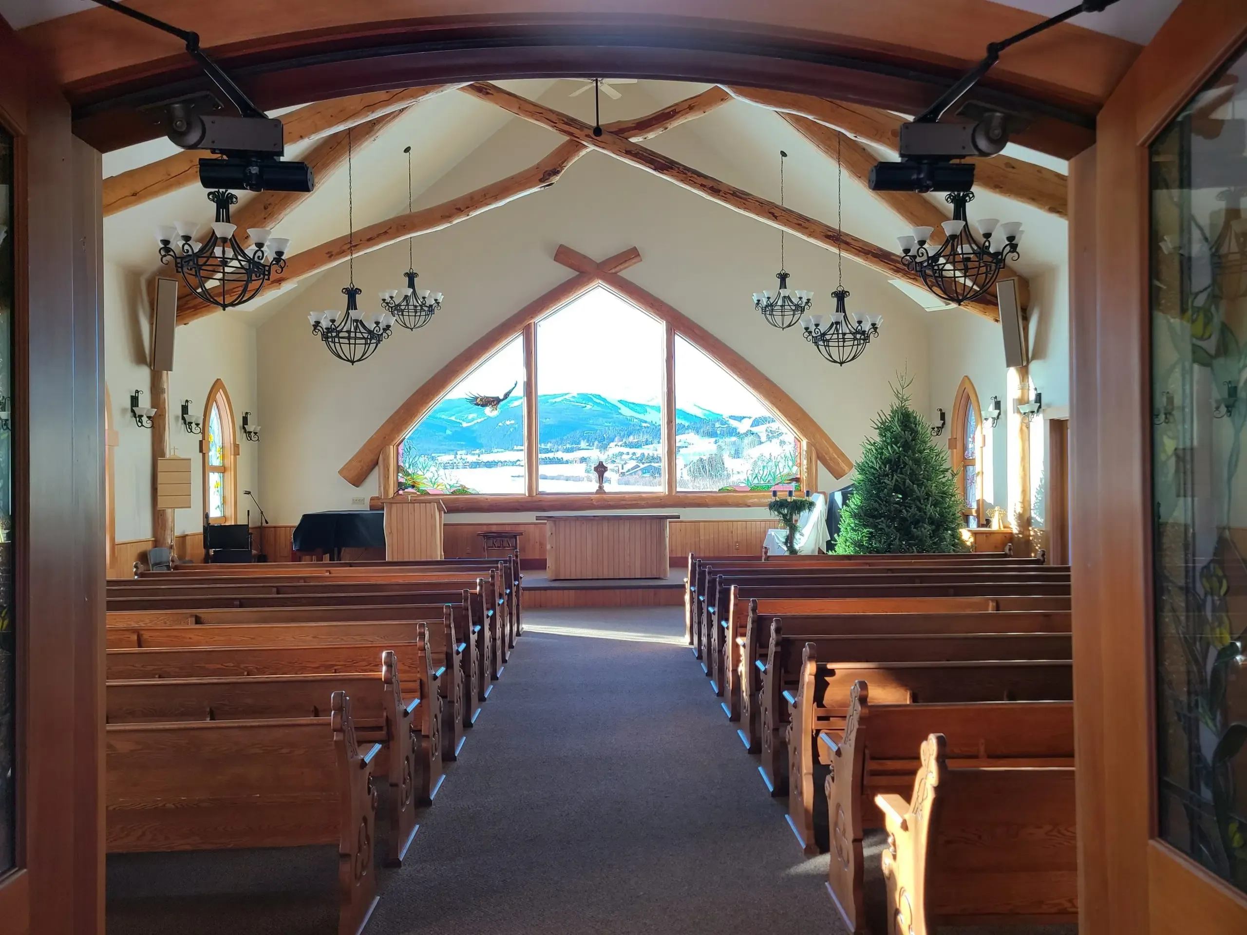 Interior of Big Sky Chapel with log beams and mountain view